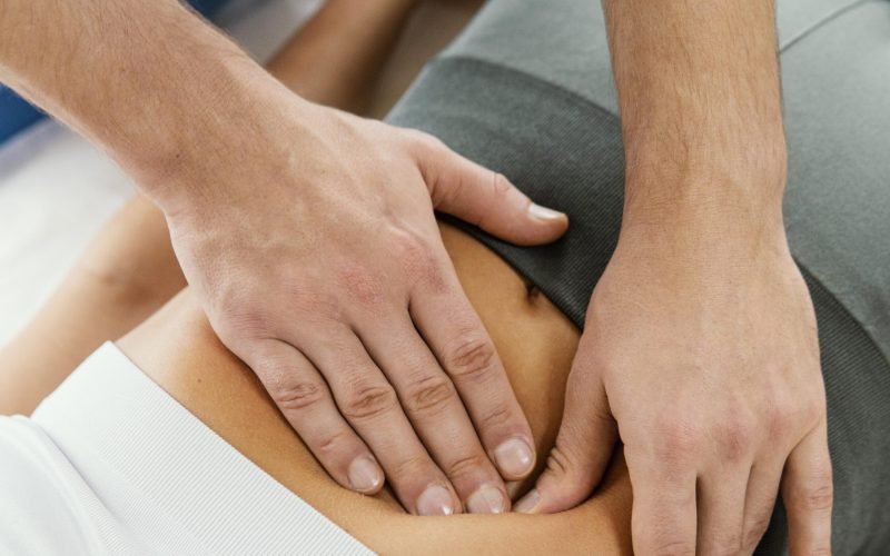 high-angleof-male-osteopathic-therapist-checking-female-patient-s-abdomen